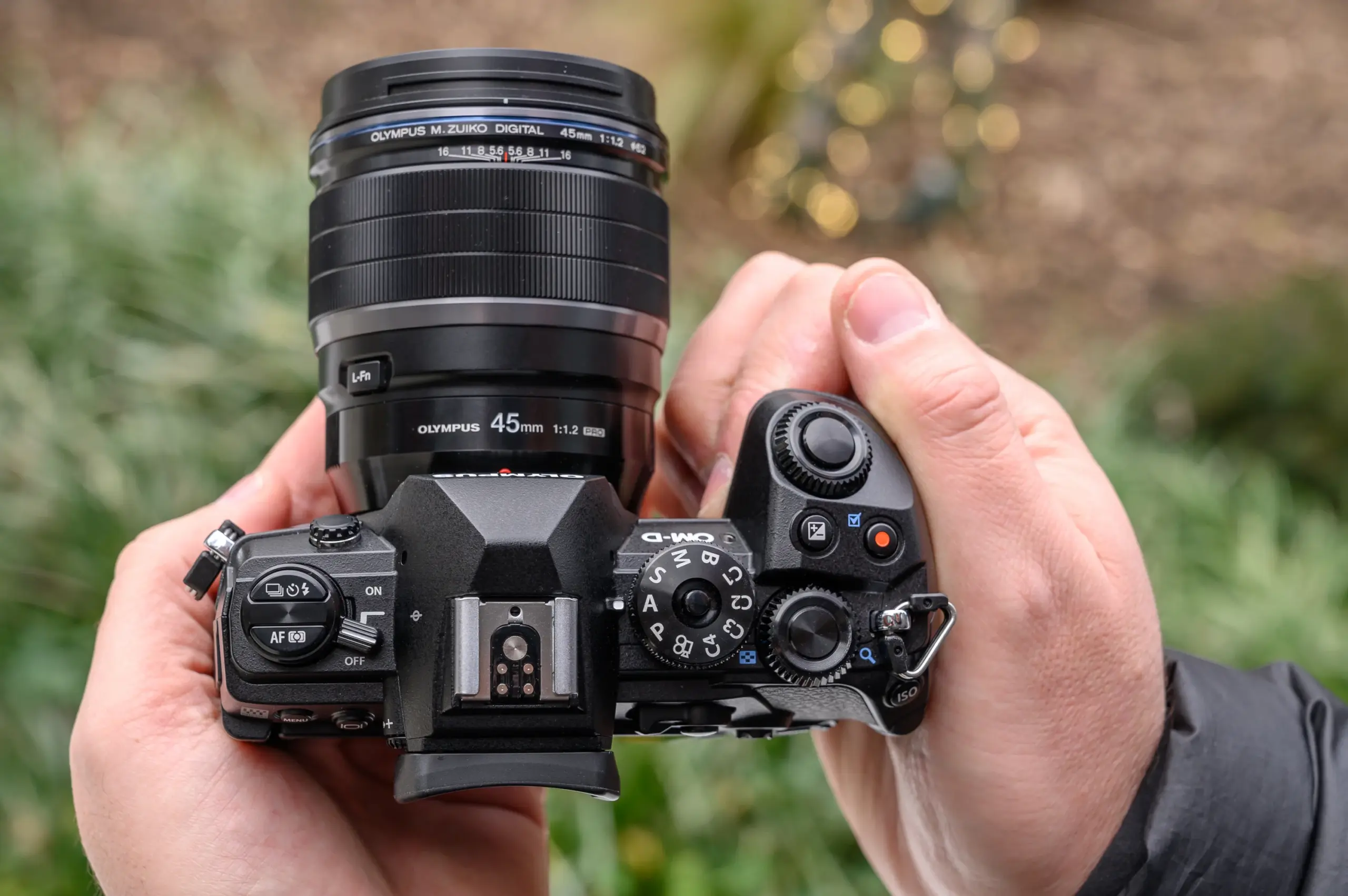 close up of hands holding olympus OM D E M1 Mark III