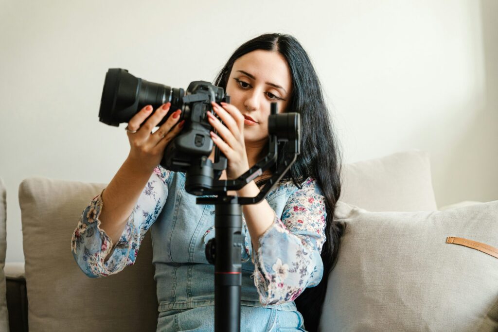 A woman adjusting her camera on a stabilizer tripod, preparing for a photoshoot.