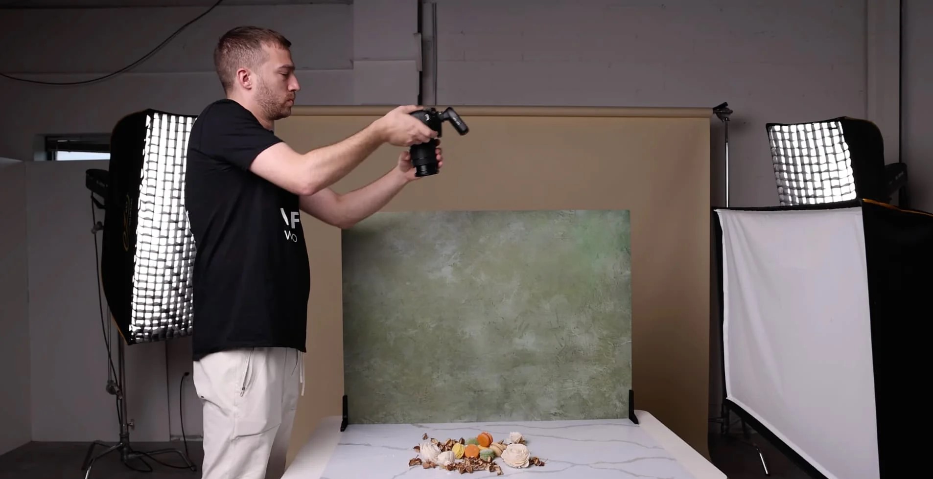 A photographer capturing a product shot from a 45-degree angle, with a setup including lighting and a background.
