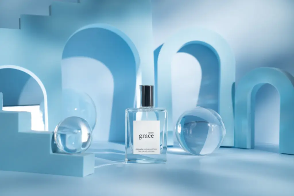 Perfume bottle displayed among blue arches and glass spheres in a clean, monochromatic product scene.