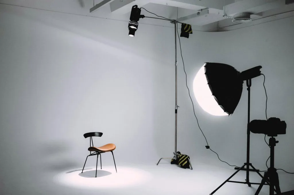 Photography studio lighting setup with softbox and chair