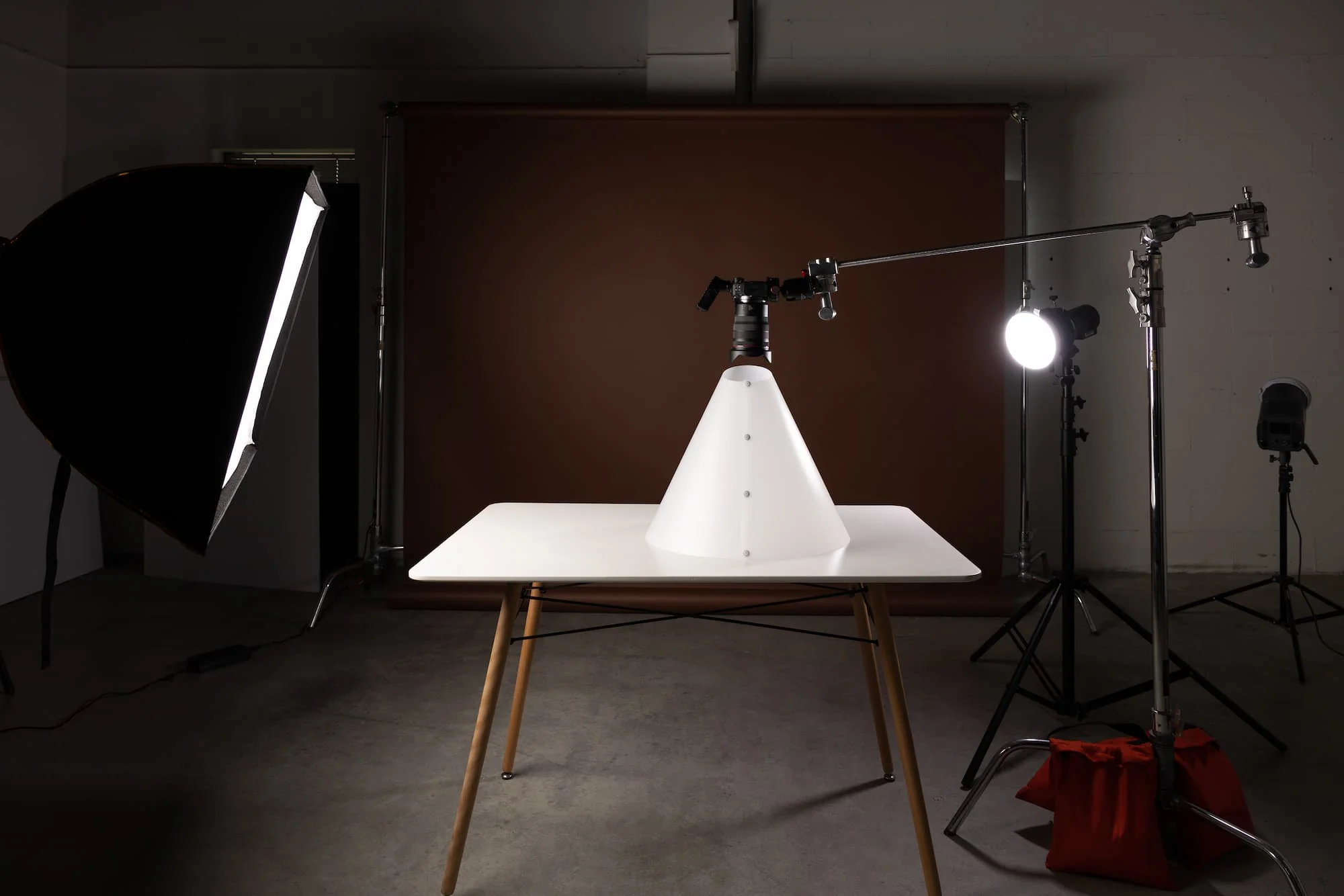 A studio product photography setup using flash lighting, softboxes, stands, and a backdrop