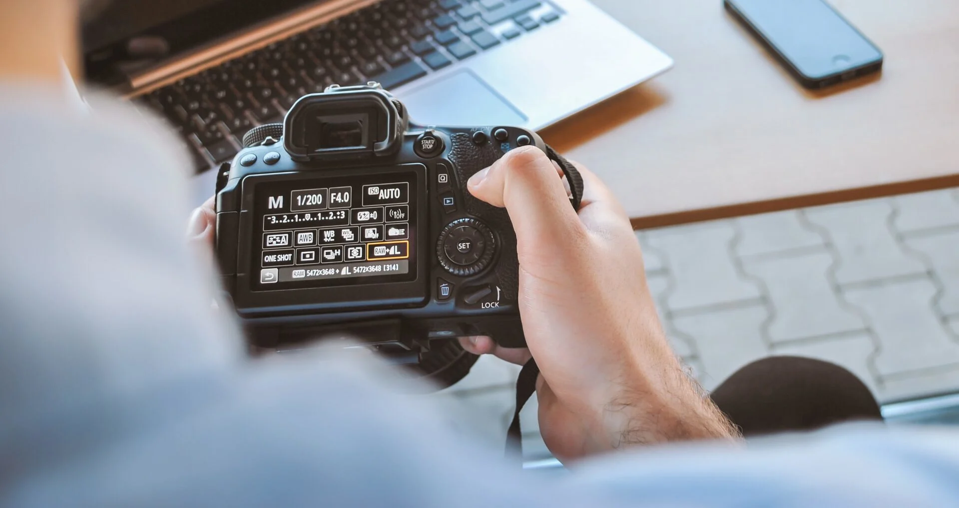 Photographer adjusting manual camera settings for flash photography.
