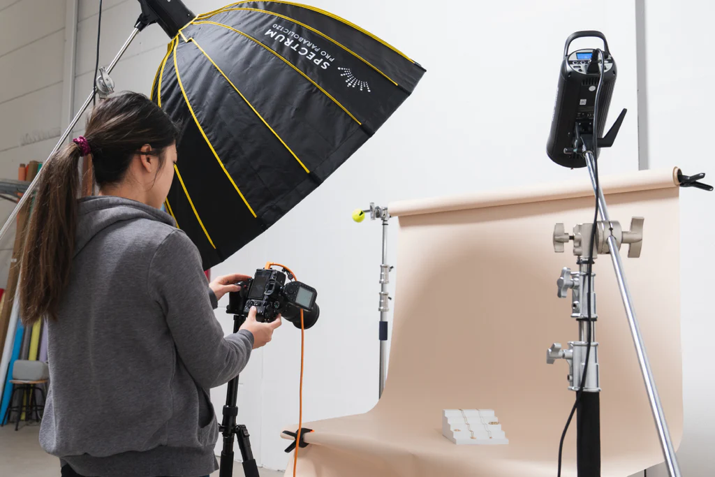 Product photographer combining flash and natural light in a studio setup.