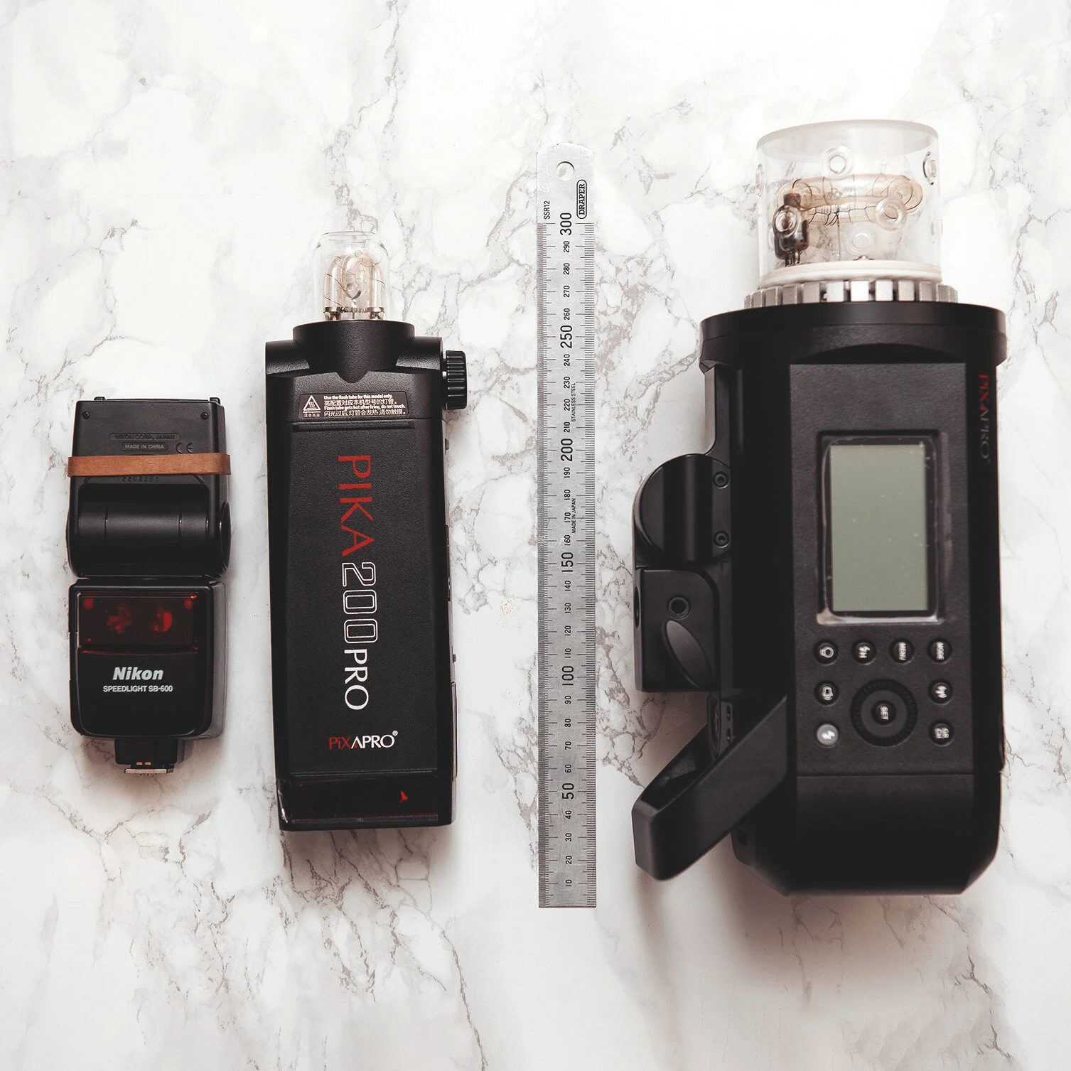 Speedlight and strobe flash units compared with a ruler.