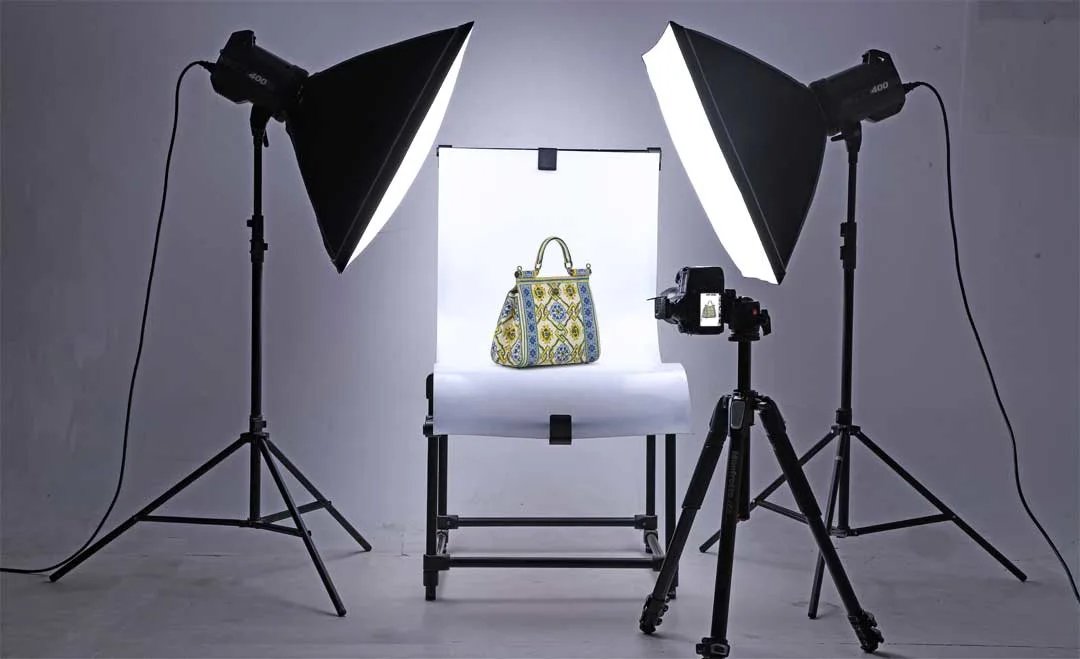 Two-light product photography setup with softboxes photographing a handbag.